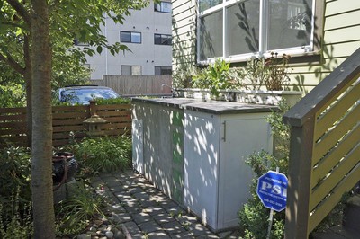 The bike shed includes several decorative features to match the decor of the house, including the dyed cement stucco, tiled backsplash, and matching cabinet-like doors.