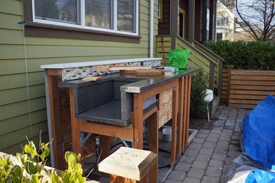 The shed under construction, showing the framing supporting the concrete countertop and roof.