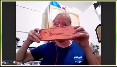 A participant uses video to share an object to the group and discuss how she plays dominos with her patient to keep her patient engaged and entertained.