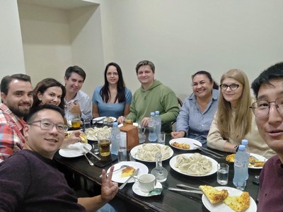 A mixed group of country fellows enjoy Georgian khinkali.